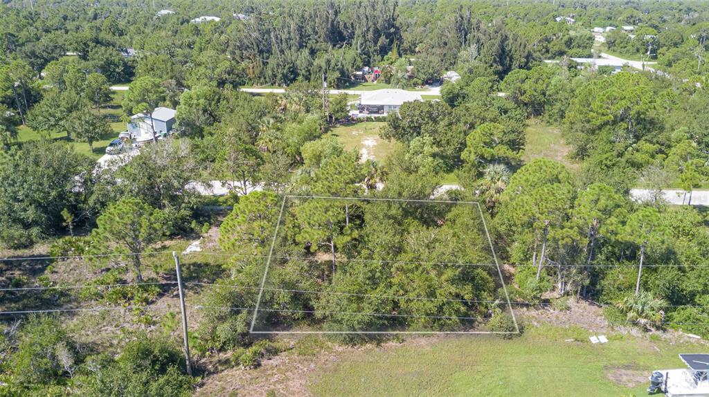 An aerial view shows a rectangular, tree-covered vacant lot outlined in white — 11356 4TH AVENUE, PUNTA GORDA, FL