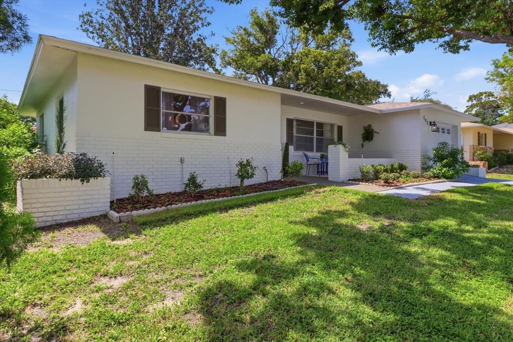 A single-story house with white brick and siding, a front lawn, and a covered porch — 203 S LEE STREET, BEVERLY HILLS, FL