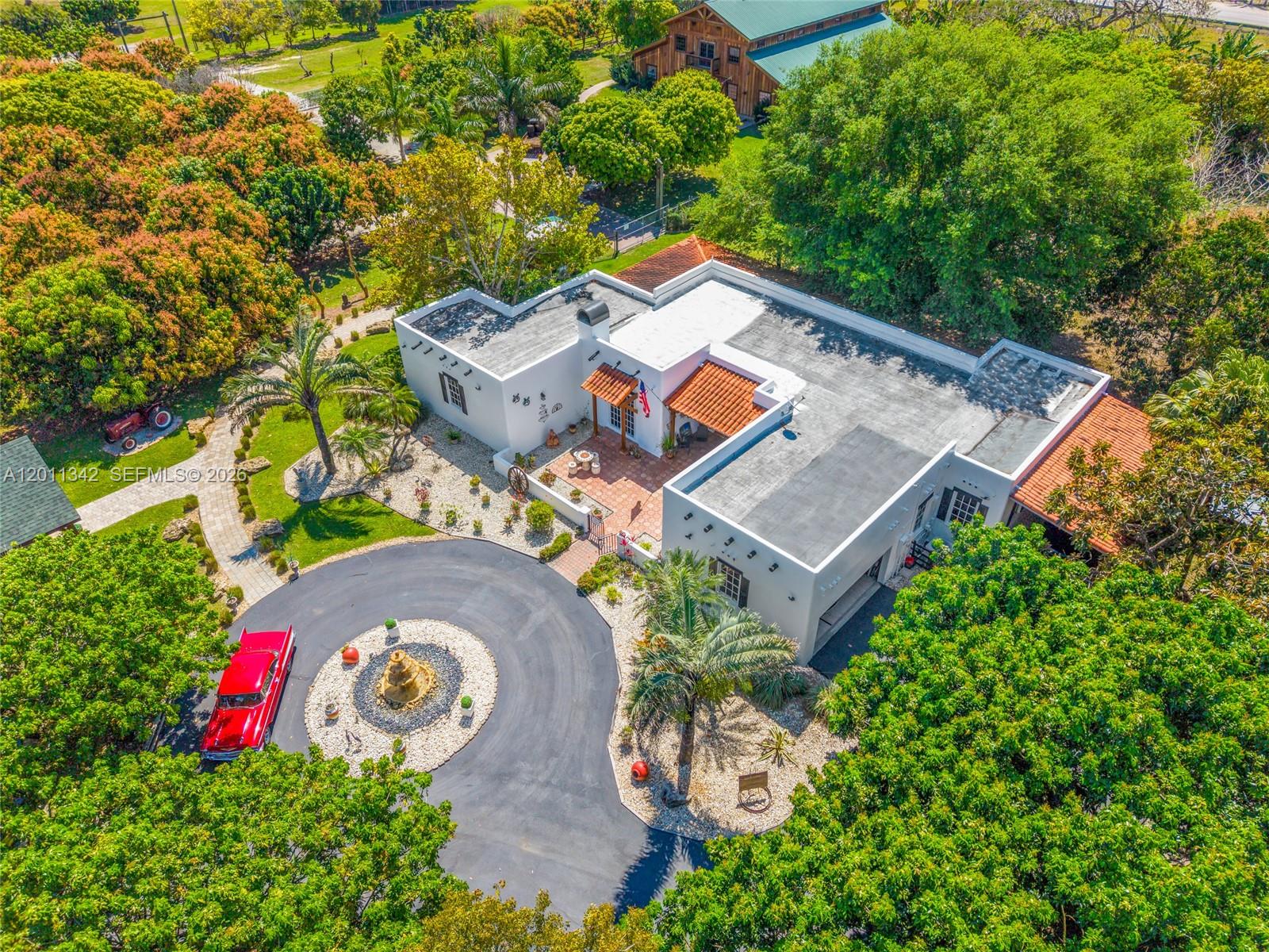 An aerial view shows a white house with a flat roof, courtyard, and circular driveway — 19050 SW 194th Ave, Miami FL 33187, MIAMI, FL