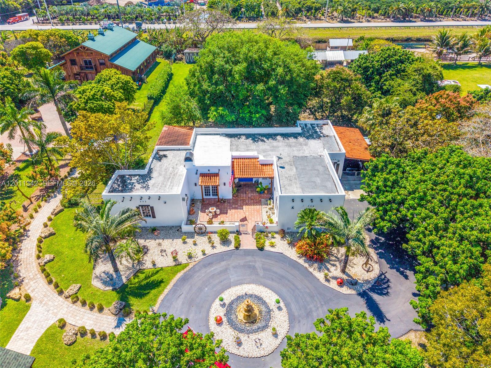An aerial view shows a white house with a flat roof, courtyard, and circular driveway — 19050 SW 194th Ave, Miami FL 33187, MIAMI, FL