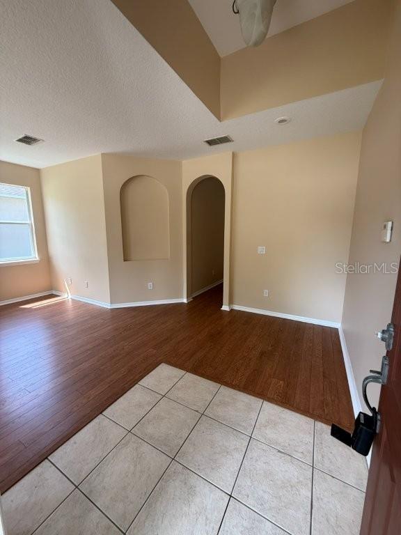 An entryway with tile flooring transitions into a living area with wood-look floors — 1102 MAGNOLIA BLOSSOM COURT, APOPKA, FL