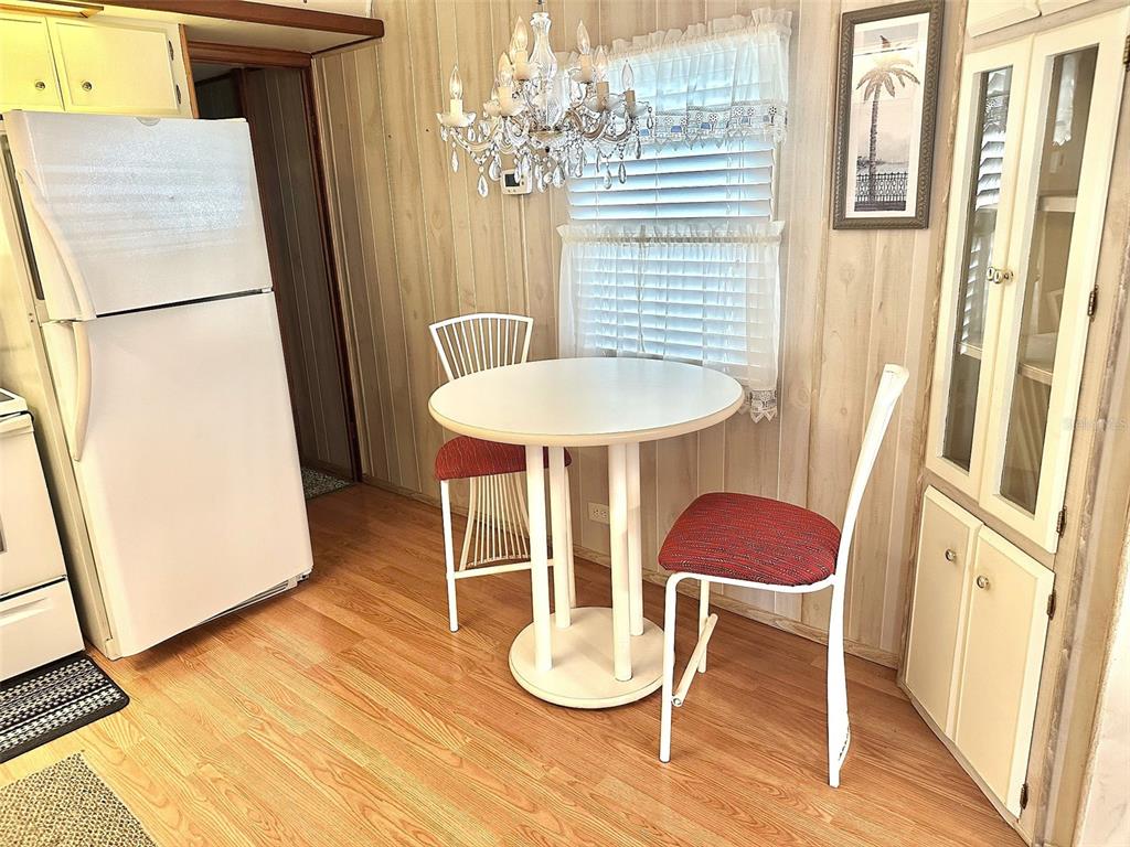 A kitchen dining area features a white table, two chairs, and a crystal chandelier — 8300 SEMINOLE BOULEVARD UNIT 241, SEMINOLE, FL