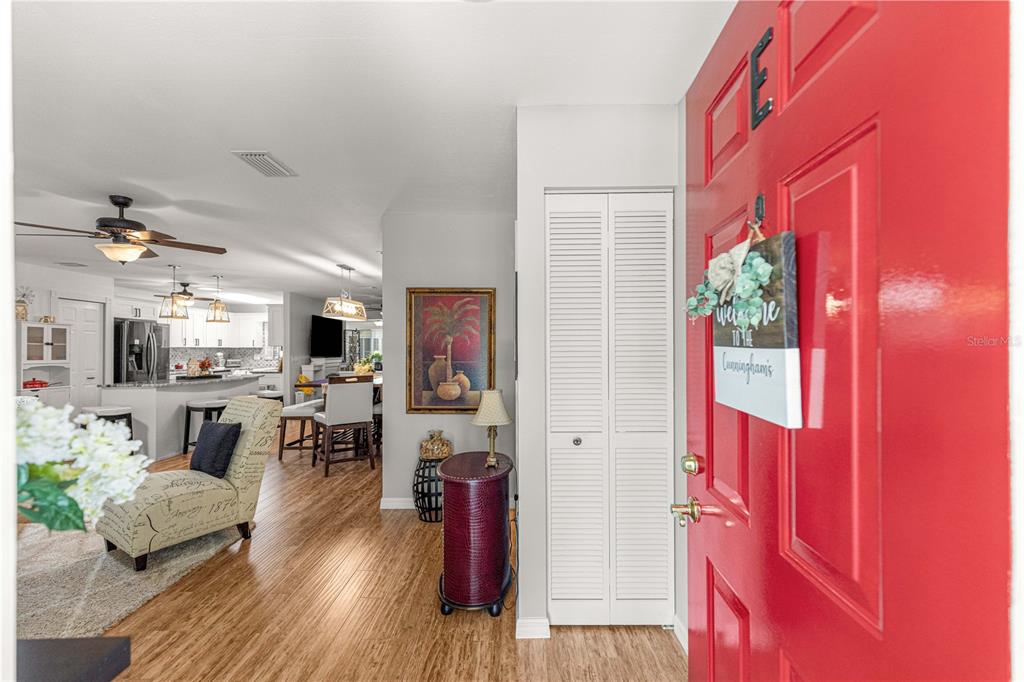 An entryway with a red front door leads into an open-concept living area and kitchen — 8874 SW 95TH STREET UNIT E, OCALA, FL
