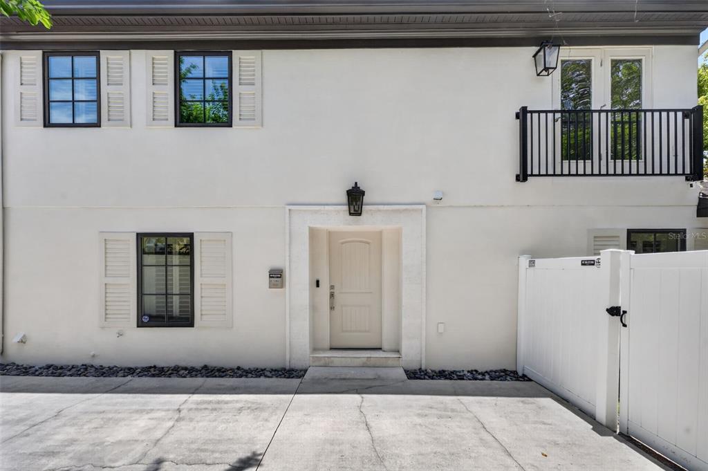 A two-story white stucco building features a central front door, black-framed windows, and a balcony — 1265 ARLINGTON PL, WINTER PARK, FL