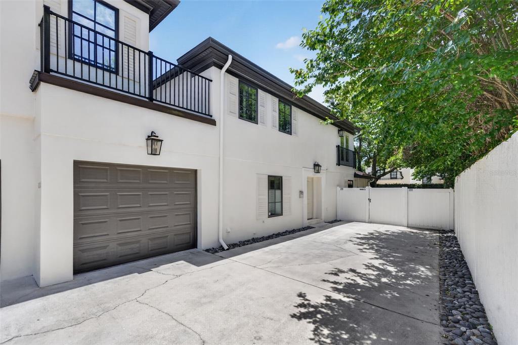 A two-story white stucco house features a garage, a balcony, and a concrete driveway — 1265 ARLINGTON PL, WINTER PARK, FL