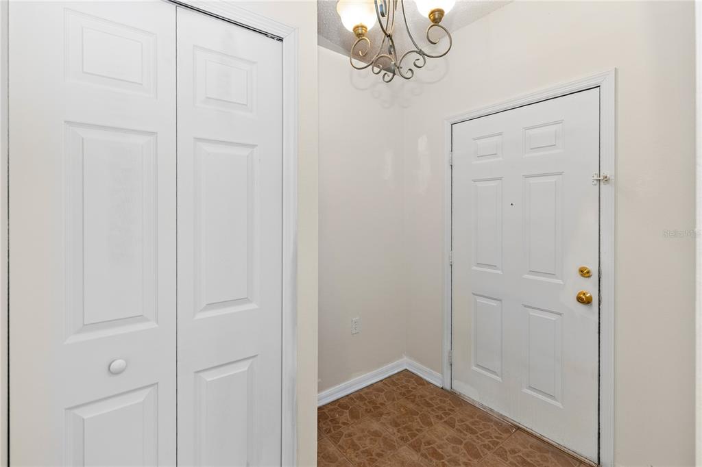 An entryway features a white front door, a bi-fold closet, and brown tiled flooring — 249 CURTIS AVENUE, GROVELAND, FL