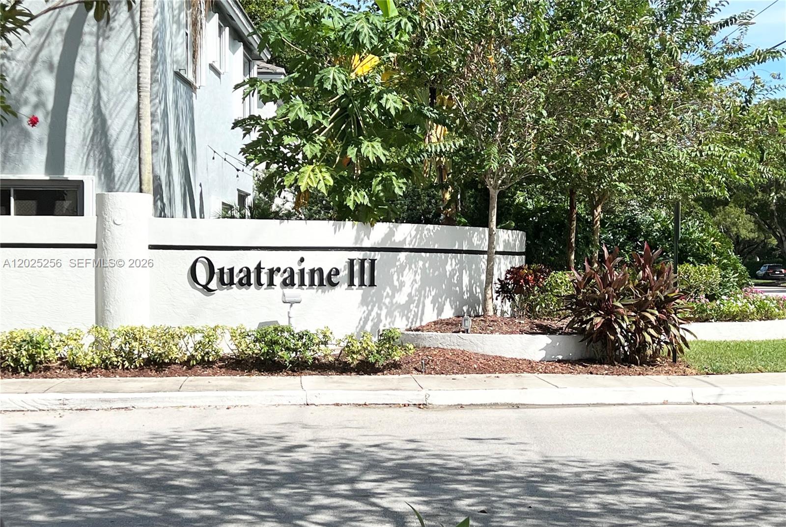 A white wall with the text Quatraine III stands in front of trees and landscaping — 9832 NW 9th Ct, Plantation FL 33324, PLANTATION, FL