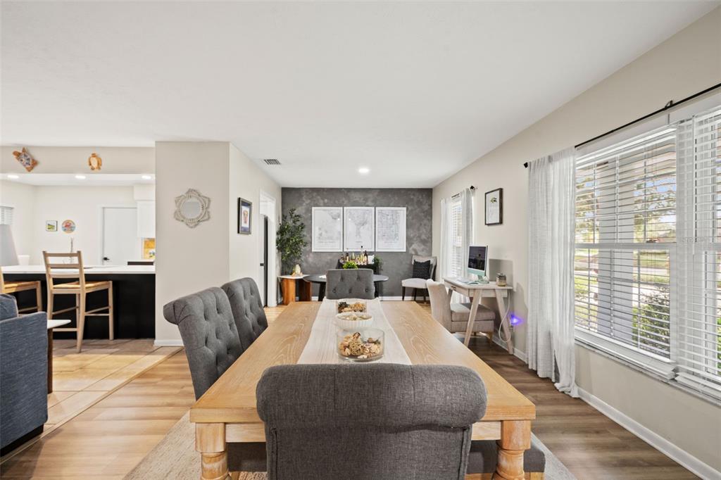 A dining room features a wooden table with grey chairs and a dark accent wall — 15521 WETSTONE DRIVE, TAMPA, FL