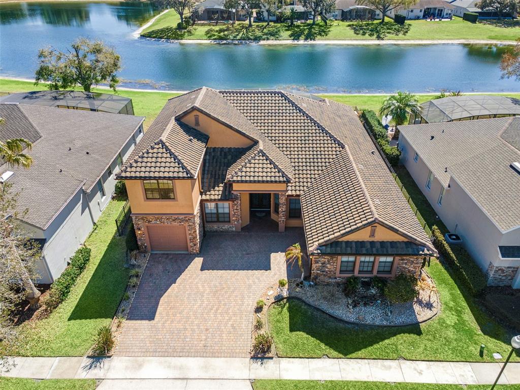 A swimming pool with three water features sits inside a screened enclosure overlooking a lake — 6473 EVERINGHAM LANE, SANFORD, FL