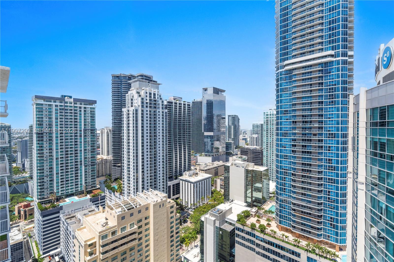 An elevated view of a dense urban skyline featuring numerous modern glass skyscrapers and buildings — 1200 Brickell Bay Dr # 4218, Miami FL 33131, MIAMI, FL