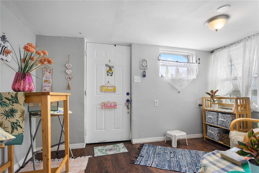 A bright entryway features a white door, light gray walls, and wood-look flooring — 221 AVENUE L NE, WINTER HAVEN, FL