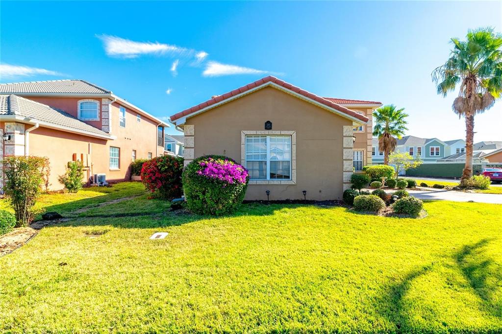 A tan, single-story house with a tiled roof sits on a grassy lawn — 284 VISTA DRIVE, DAVENPORT, FL