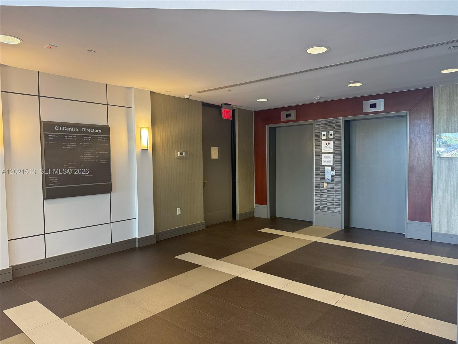 An office building lobby features a directory sign, a closed door, and two elevator doors — 290 NW 165th St # 5A, Miami FL 33169, MIAMI, FL