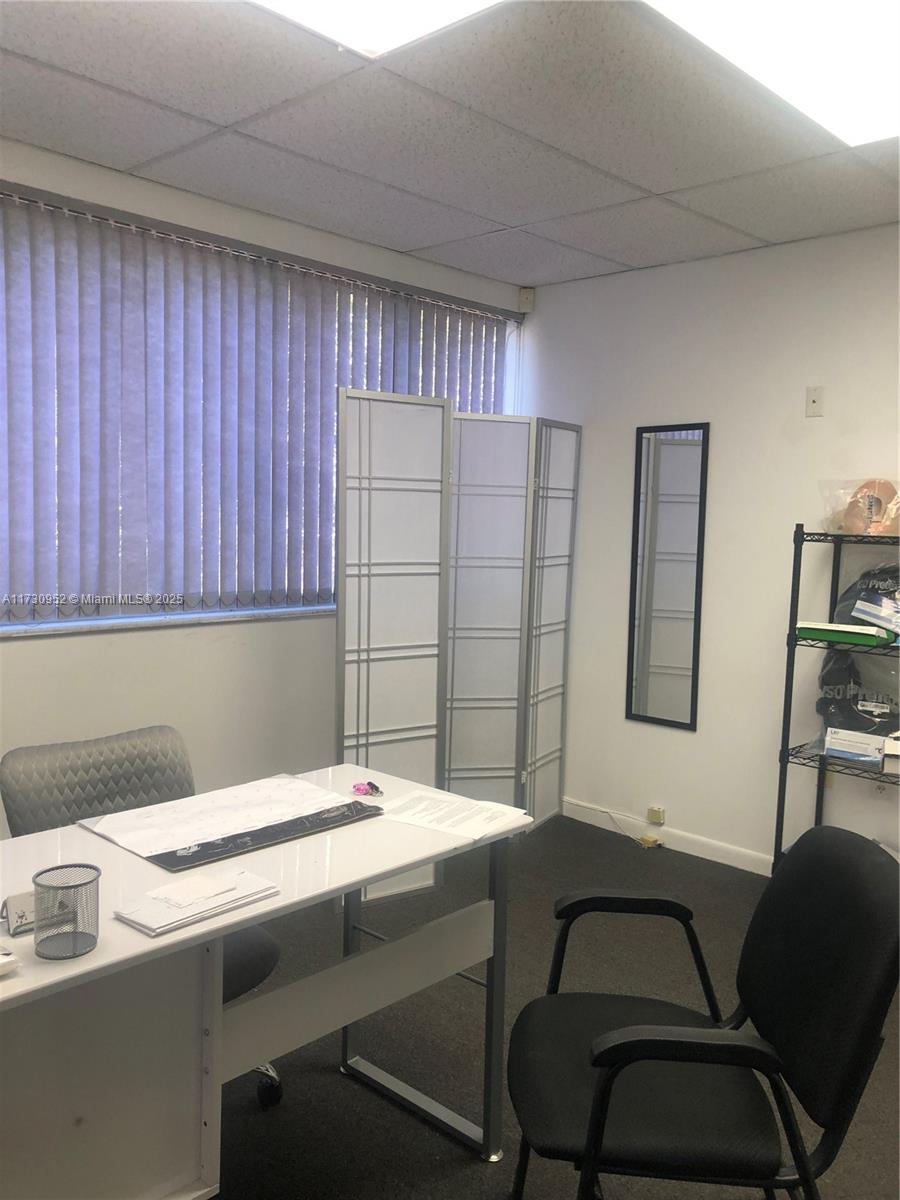 An office room features a white desk, a black chair, a folding screen, and a mirror — 1385 SW 22 # 203, Coral Gables FL 33145, CORAL GABLES, FL