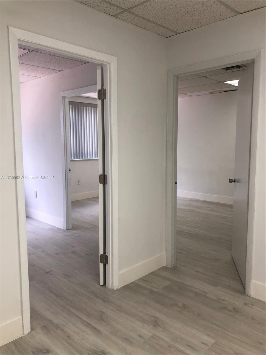 Two doorways lead into separate office rooms with light-colored wood-look flooring and white walls — 1385 SW 22 # 203, Coral Gables FL 33145, CORAL GABLES, FL