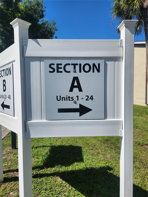 A white signpost displays directions to Section A, Units 1-24 and Section B, Units 25-48 — 22481 WESTCHESTER BOULEVARD UNIT A19, PUNTA GORDA, FL