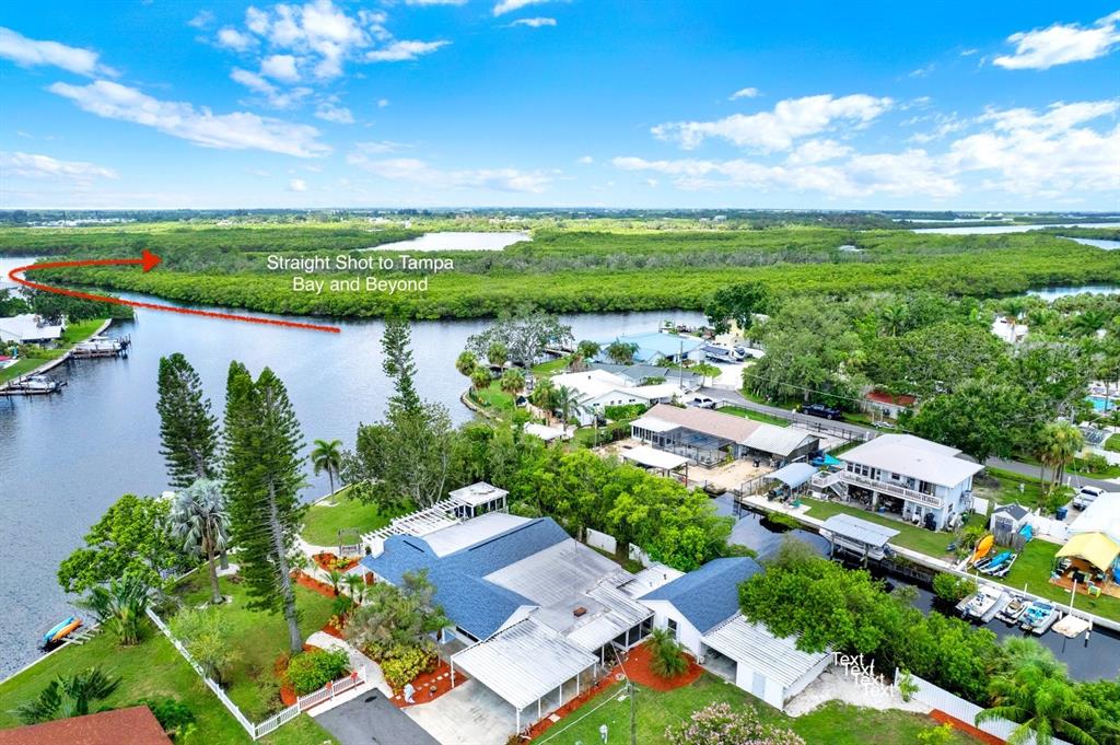 An aerial view of a waterfront house with a red arrow pointing toward Tampa Bay — 102 W NORTH BRANCH ROAD, RUSKIN, FL