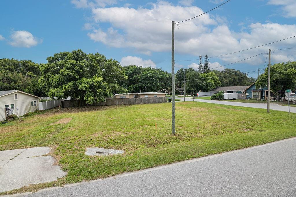 A vacant, grassy residential lot sits at a corner intersection with a utility pole — 5102 SUNRISE BOULEVARD, ORLANDO, FL