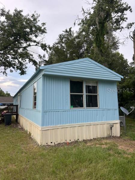 A light blue mobile home with a metal exterior sits on a grassy lot — 3563 SE 147TH PLACE, SUMMERFIELD, FL