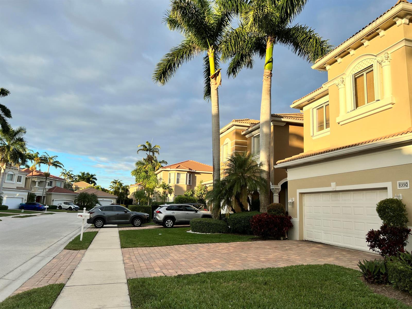 A suburban street scene features two-story tan houses, palm trees, and parked cars — 4350 Key Lime Boulevard, Boynton Beach FL 33436, BOYNTON BEACH, FL