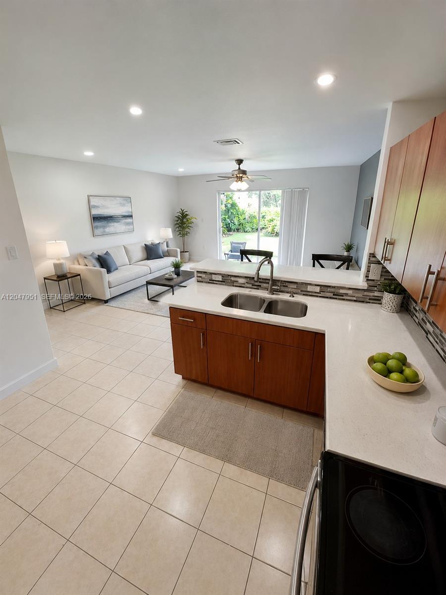 A modern kitchen features wood cabinets, stainless steel appliances, and a white countertop — 3092 SW 129th Ter # 102, Miramar FL 33027, MIRAMAR, FL