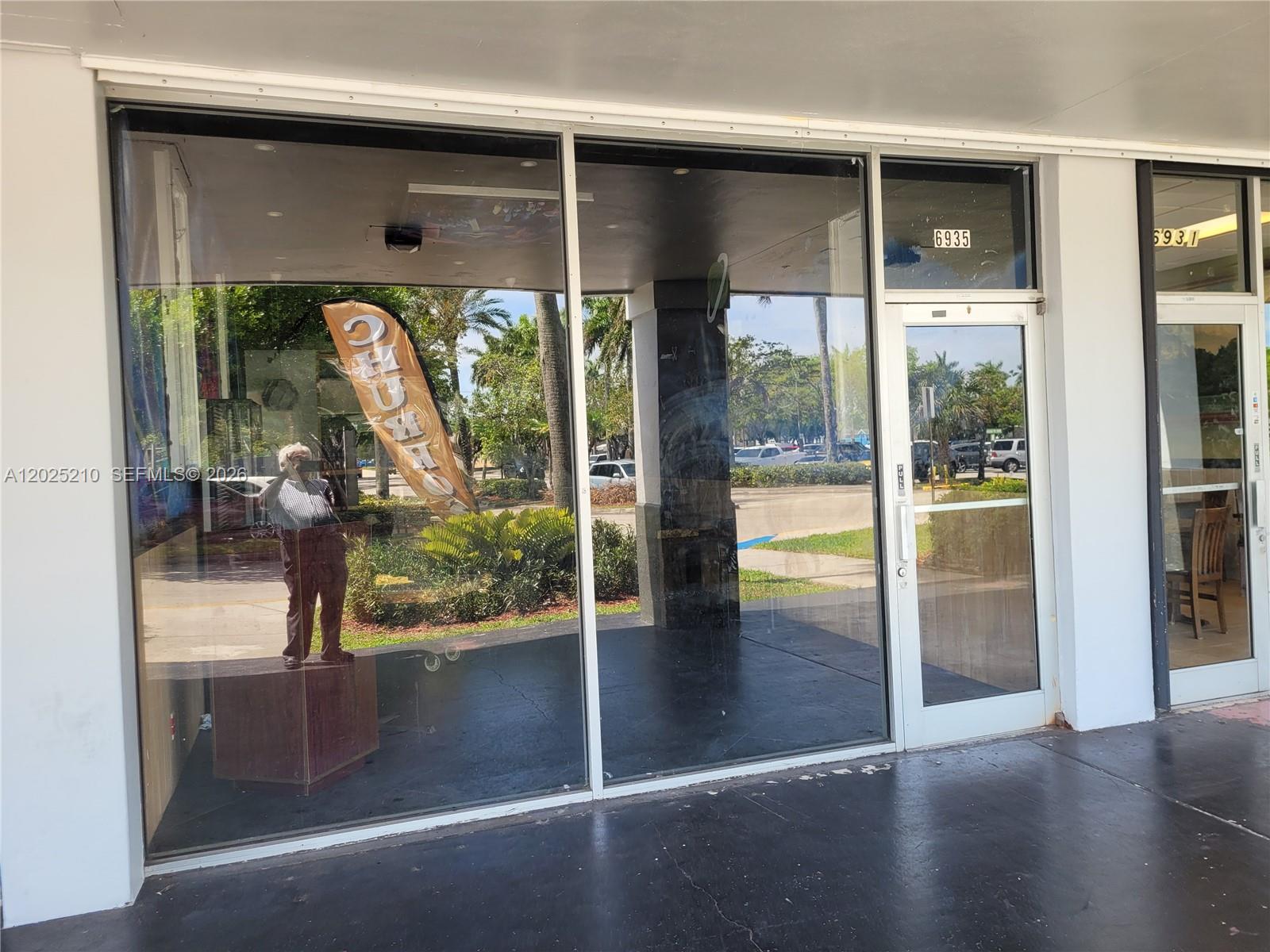 The exterior view shows a storefront with large glass windows and a glass-paneled entry door — 6935 Taft, Hollywood FL 33125, HOLLYWOOD, FL
