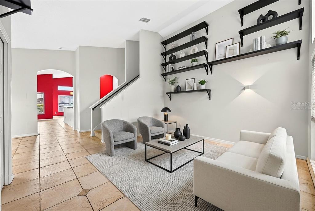 A living room features a white sofa, two gray armchairs, and black wall-mounted shelving — 2551 WALNUT HEIGHTS ROAD, APOPKA, FL