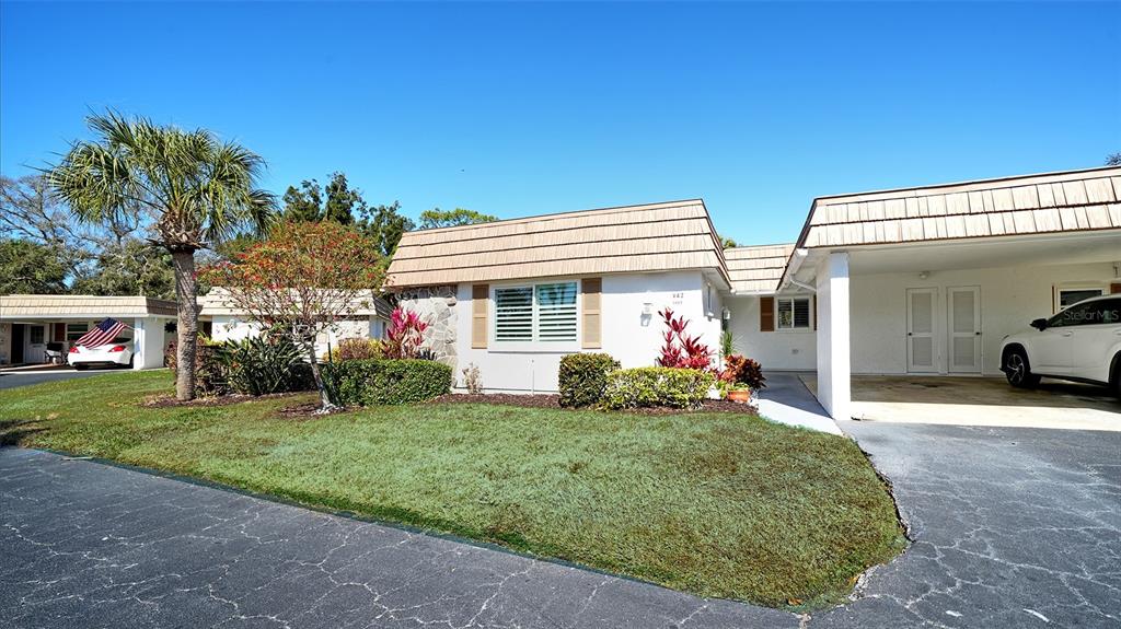 A single-story house with a white exterior, a mansard roof, and an attached carport — 5469 RIVERBLUFF CIRCLE UNIT 42, SARASOTA, FL