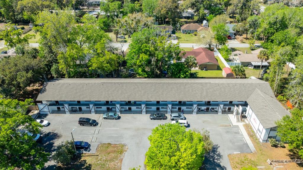 An aerial view shows a long, single-story motel building with a parking lot in front — 1216 KENNEDY ROAD, DAYTONA BEACH, FL