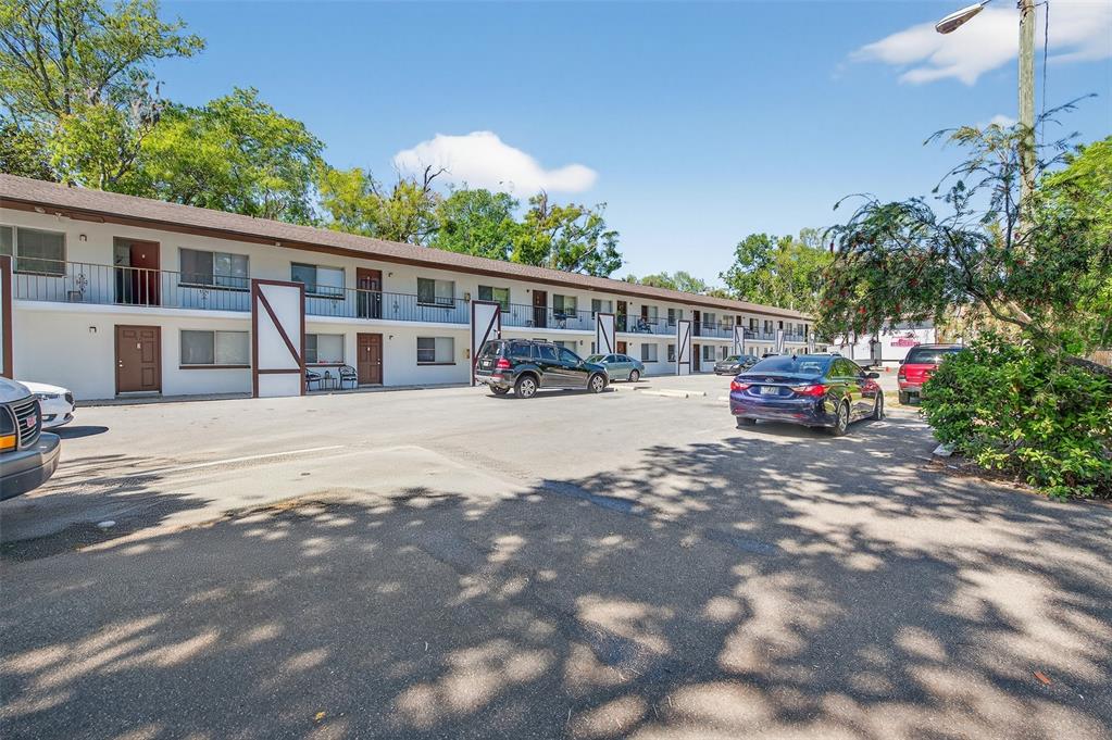 A two-story apartment building with a parking lot in front under a blue sky — 1216 KENNEDY ROAD, DAYTONA BEACH, FL