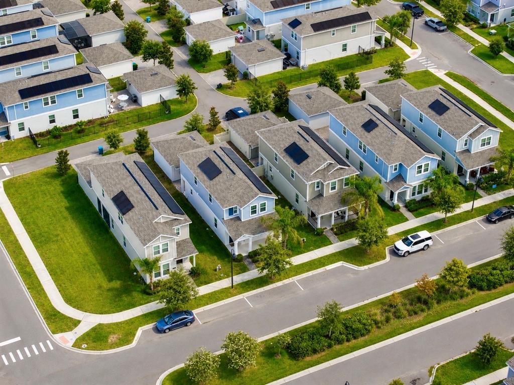 An aerial view shows several two-story houses with solar panels on their shingled roofs — 17119 QUICKSILVER AVENUE, WINTER GARDEN, FL