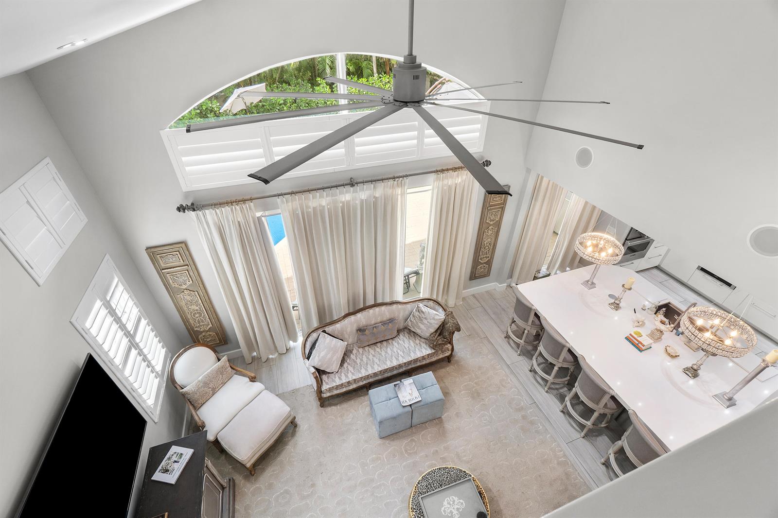High-angle view of a living room and kitchen with a large ceiling fan and windows — 2550 NW 52nd Street, Boca Raton FL 33496, BOCA RATON, FL