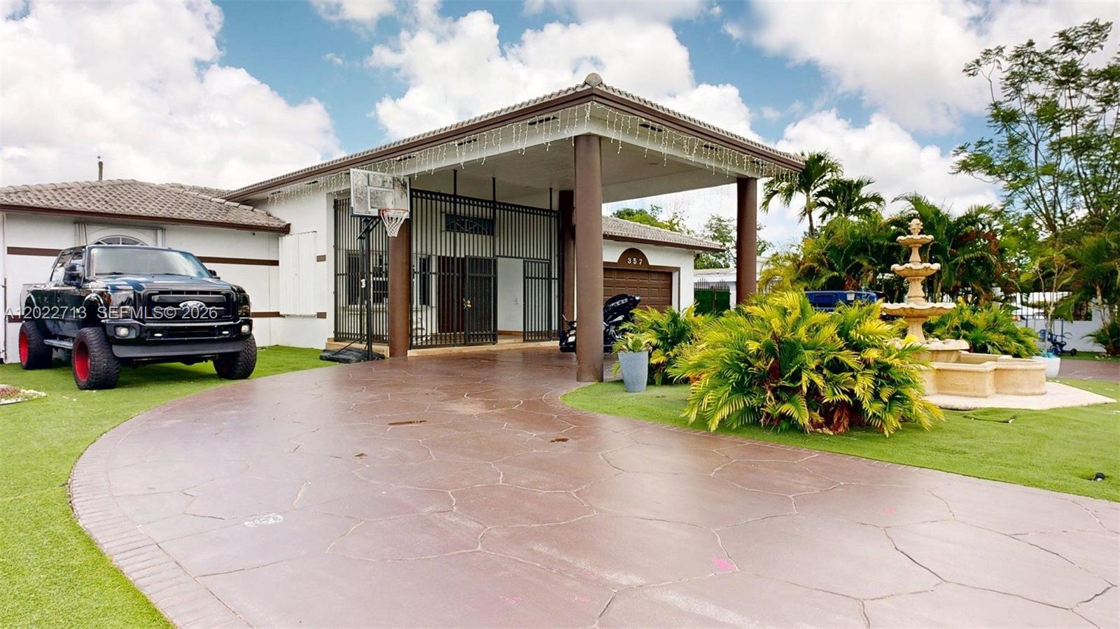 A house exterior features a large covered entryway, a basketball hoop, and a stone fountain — 357 W 44th St, Hialeah FL 33012, HIALEAH, FL