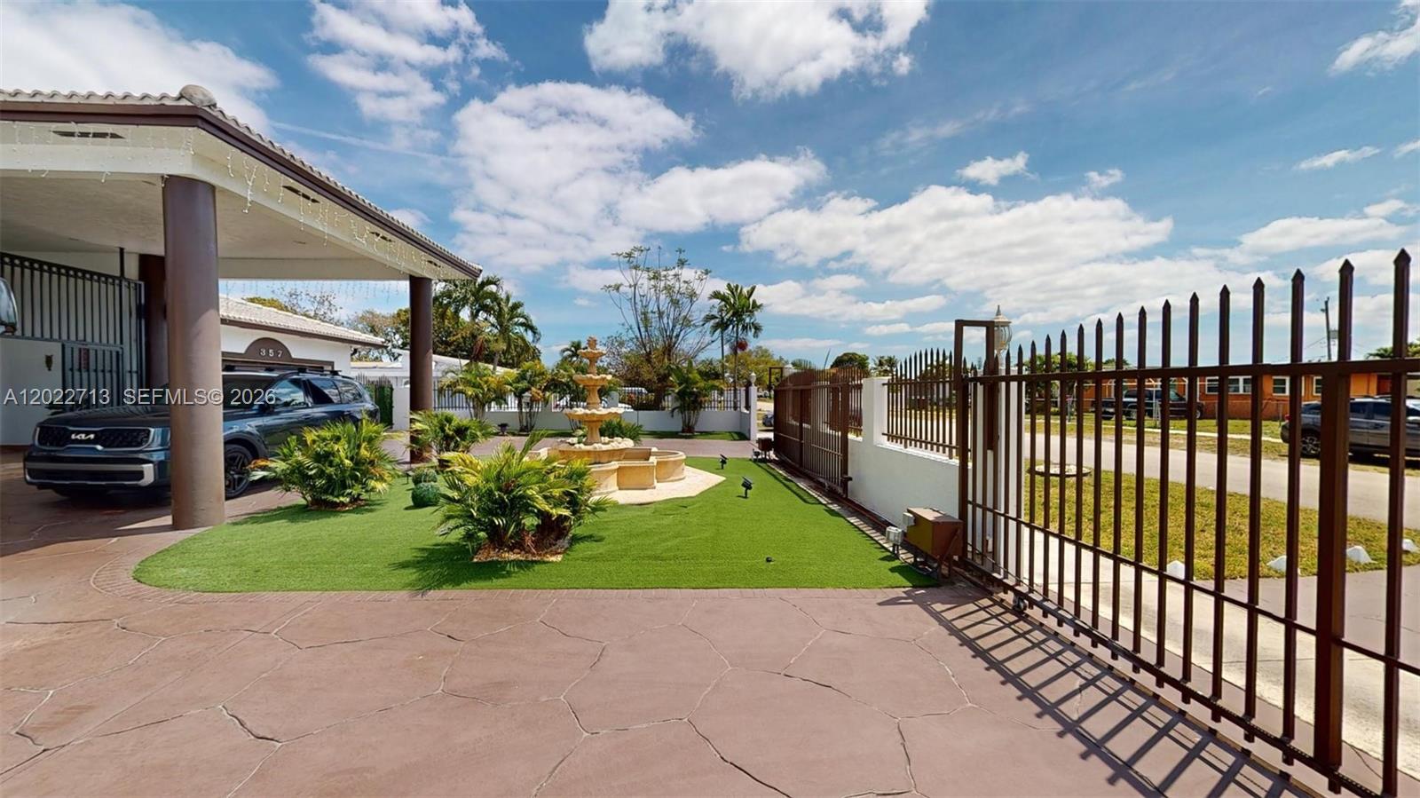 A driveway leads to a house entrance with a fountain and a metal gate — 357 W 44th St, Hialeah FL 33012, HIALEAH, FL