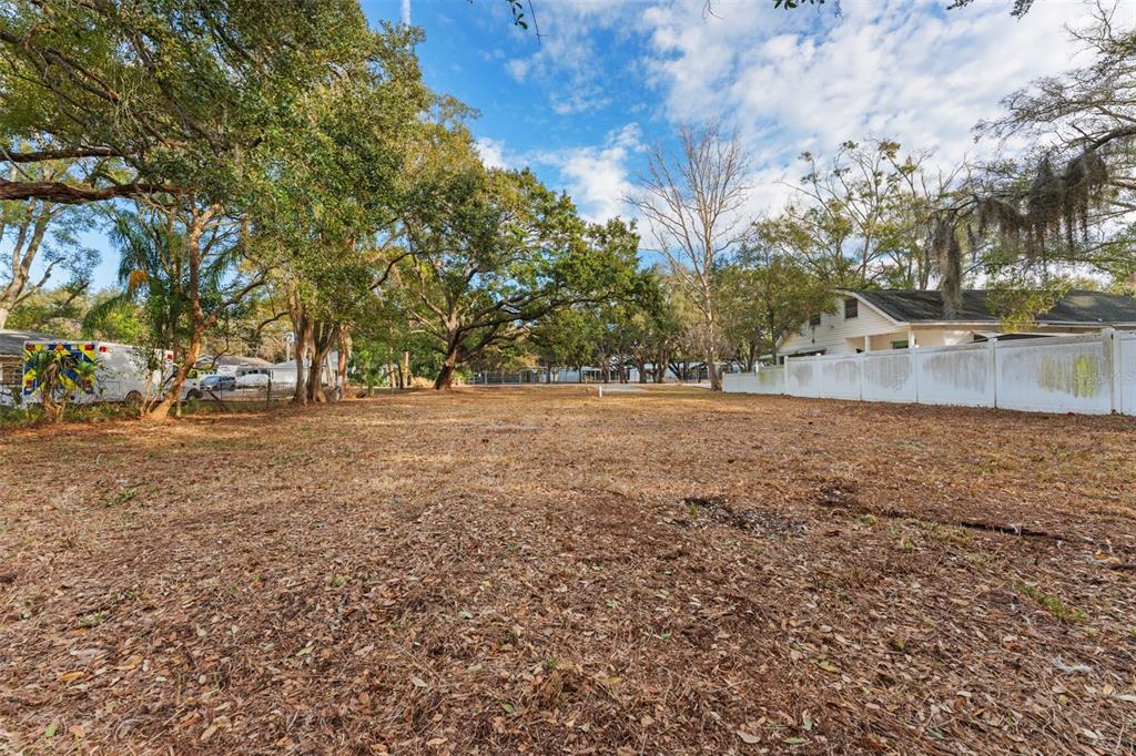 A large, cleared residential lot features mature oak trees and an adjacent white house — 503 BUCKINGHAM AVENUE W, OLDSMAR, FL