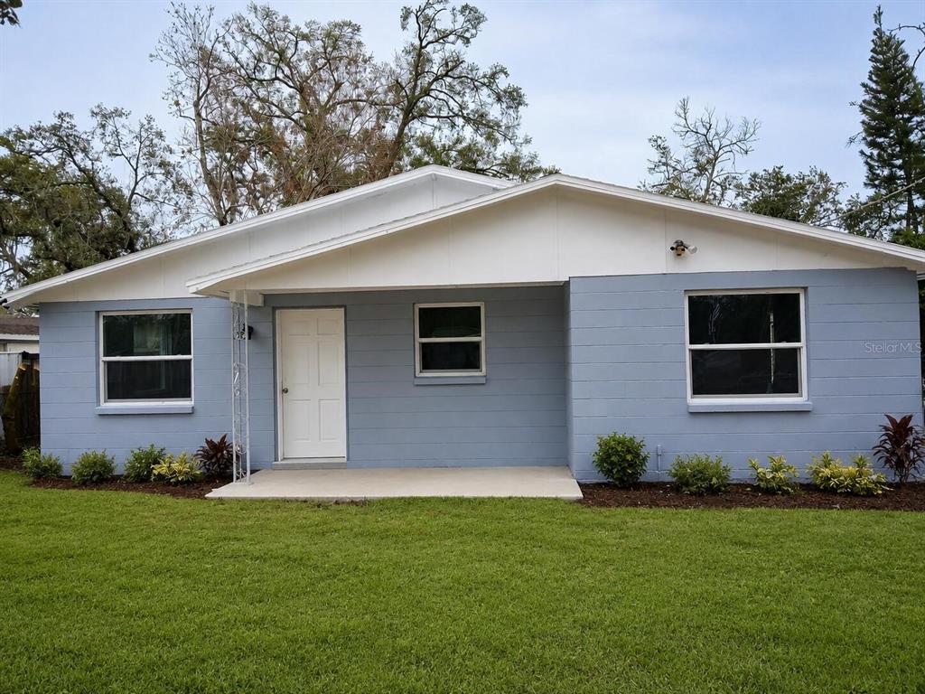 A single-story house with blue siding, a white roofline, and a front porch — 7510 ALMARK STREET, TAMPA, FL