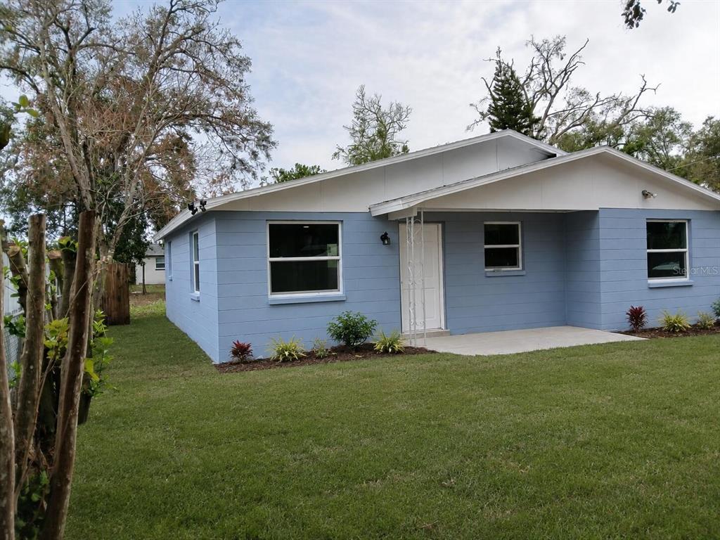 A single-story blue house with a white roof and a small front concrete porch — 7510 ALMARK STREET, TAMPA, FL