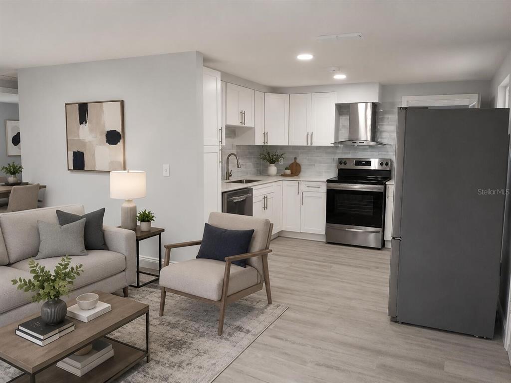 A modern open-concept kitchen and living area featuring white cabinetry, stainless steel appliances, and flooring — 7510 ALMARK STREET, TAMPA, FL