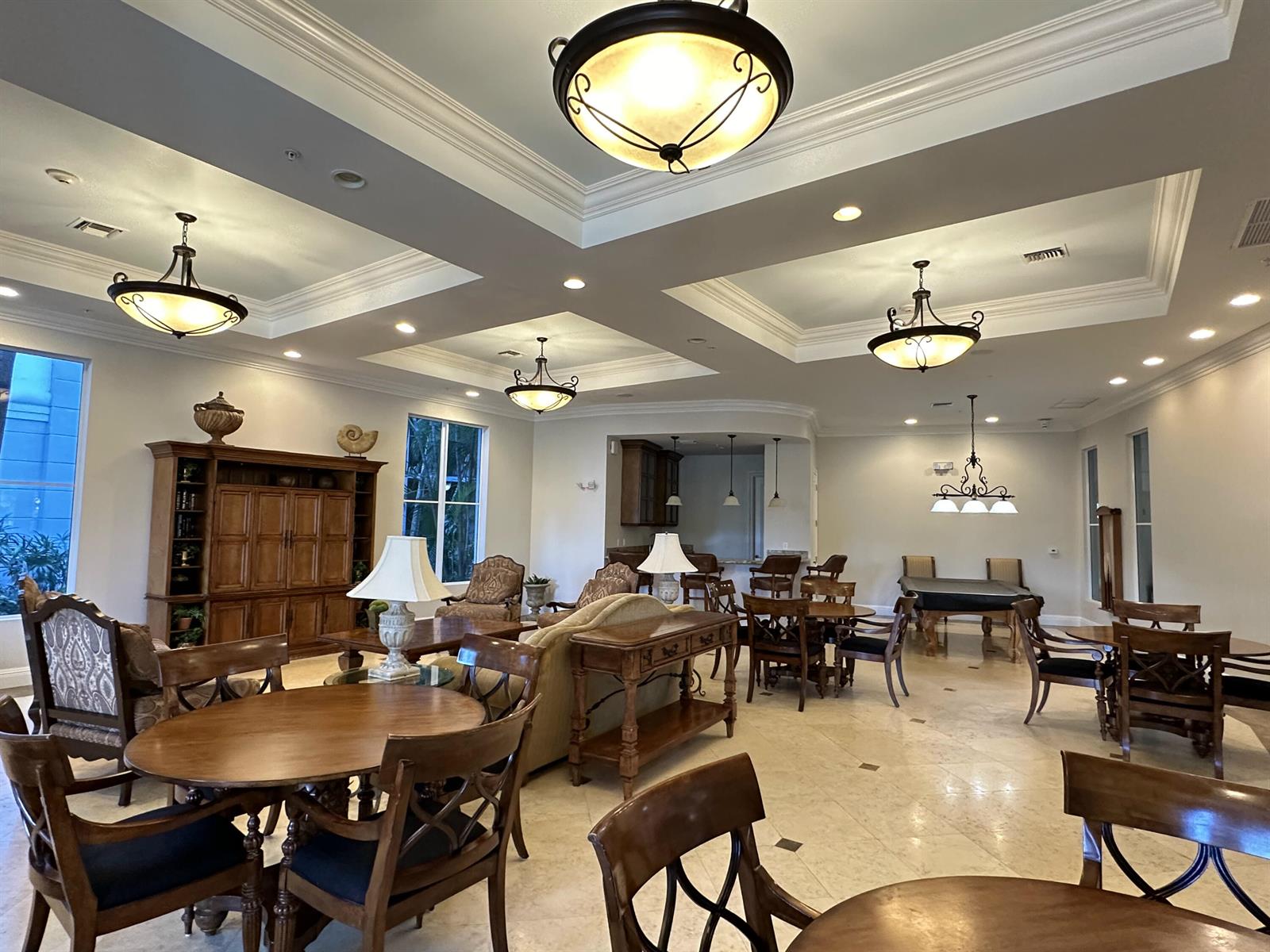 A spacious community room features coffered ceilings, tile flooring, multiple seating areas, and a pool table — 1660 Renaissance Commons Boulevard # 2507, Boynton Beach FL 33426, BOYNTON BEACH, FL