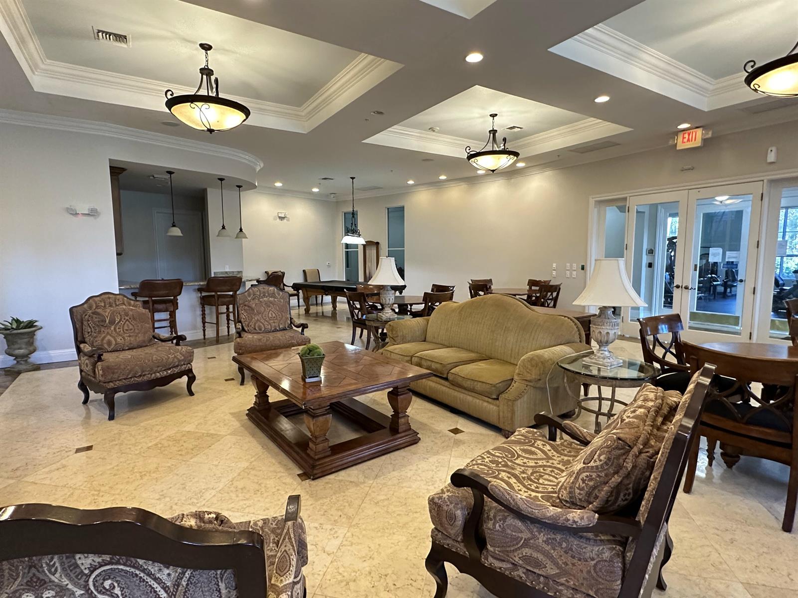 A spacious clubhouse lounge features tile floors, coffered ceilings, a bar area, and traditional furniture — 1660 Renaissance Commons Boulevard # 2507, Boynton Beach FL 33426, BOYNTON BEACH, FL