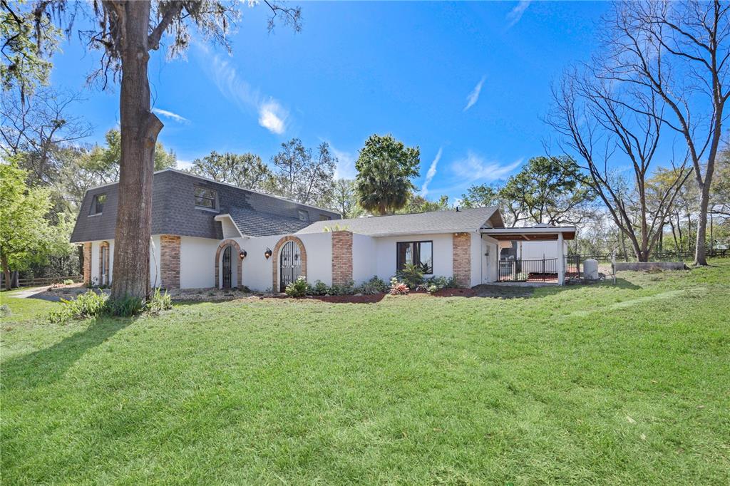 A two-story house with a white exterior, brick accents, and a large grassy yard — 2830 SE 31ST STREET, OCALA, FL