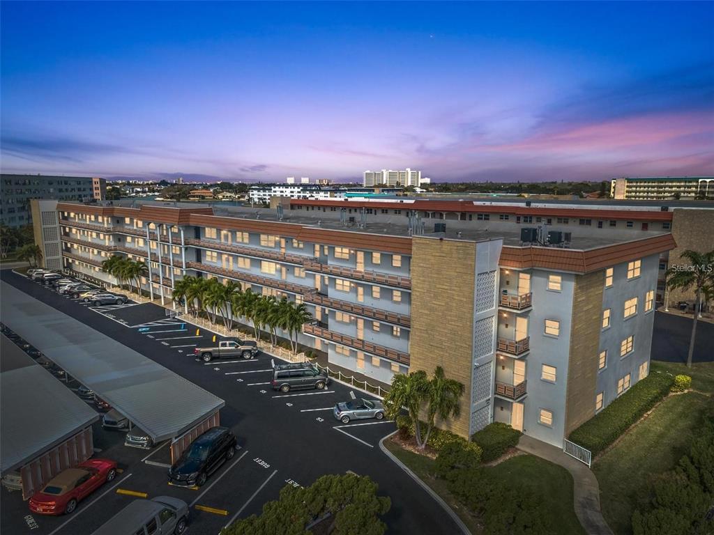 An exterior balcony with a metal railing overlooks a parking lot and a coastal street — 3128 59TH STREET S UNIT 303, GULFPORT, FL