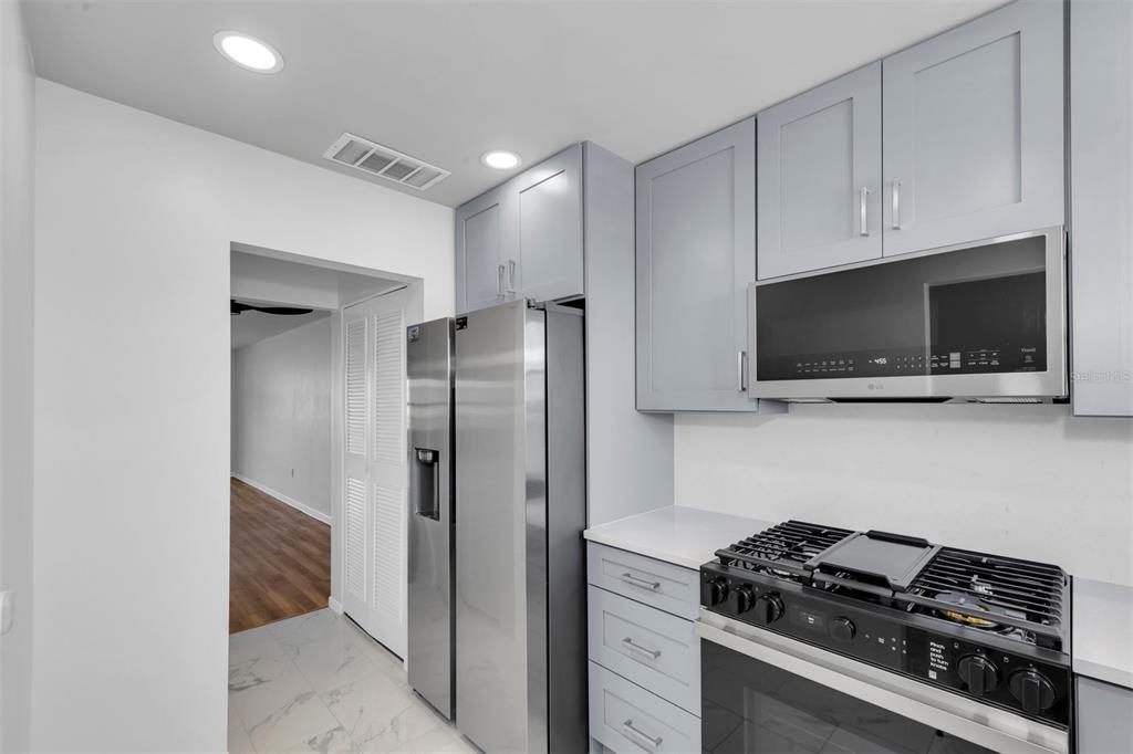 A kitchen features light gray cabinets, stainless steel appliances, and white countertops — 3128 59TH STREET S UNIT 303, GULFPORT, FL