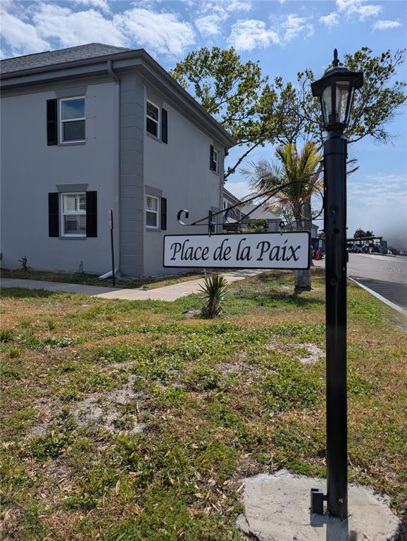 A black lamp post with a hanging sign reading Place de la Paix stands outdoors — 6990 PLACE DE LA PAIX UNIT 1A, SOUTH PASADENA, FL