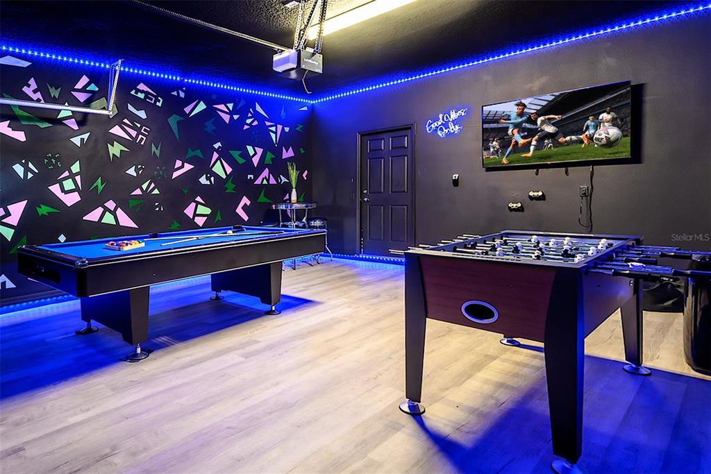 A game room features a pool table, foosball table, neon lighting, and a wall-mounted television — 1893 GOBI DRIVE, KISSIMMEE, FL