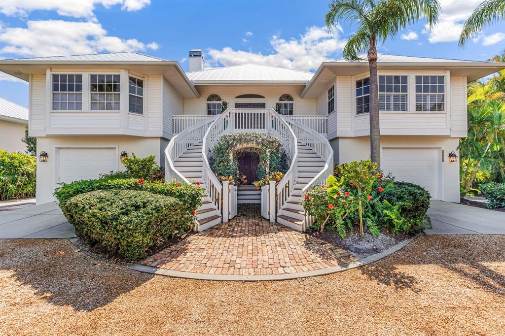 A two-story house features a symmetrical exterior with dual staircases leading to a central entrance — 1678 JOSE GASPAR DRIVE, BOCA GRANDE, FL