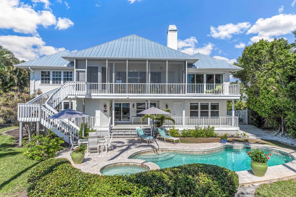 A two-story house with a metal roof, screened balcony, and a backyard pool and spa — 1678 JOSE GASPAR DRIVE, BOCA GRANDE, FL