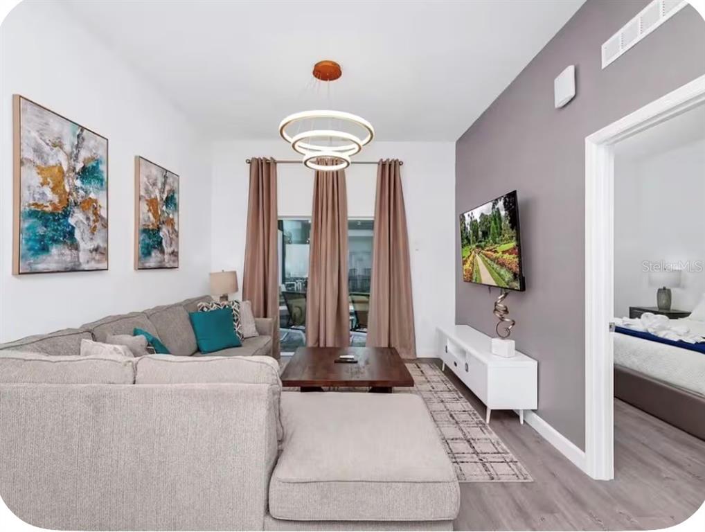 A living room features a grey sectional sofa, a wooden coffee table, and a wall-mounted television — 363 FAMAGUSTA DRIVE, DAVENPORT, FL