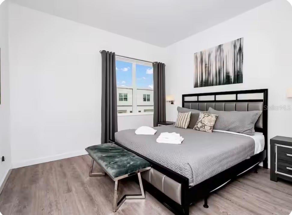 A bedroom features a bed with a black frame, gray bedding, and a velvet bench — 363 FAMAGUSTA DRIVE, DAVENPORT, FL