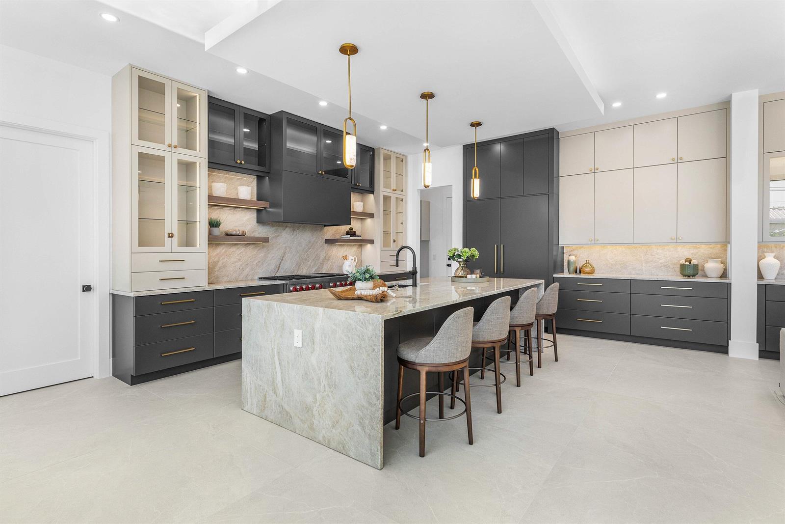 A modern kitchen features a stone waterfall island, dark and light cabinetry, and gold accents — 435 NE 15th Terrace, Boca Raton FL 33432, BOCA RATON, FL